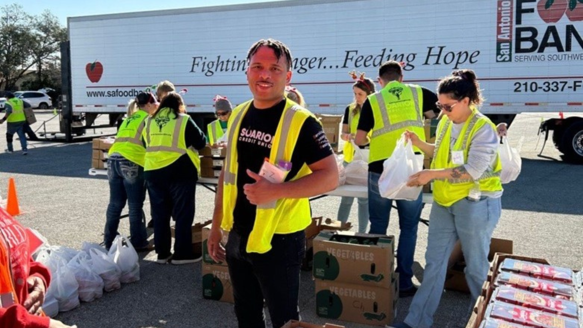 Soarion employee in a yellow vest at a volunteer event giving a thumbs up Soarion employee in a yellow vest at a volunteer event giving a thumbs up