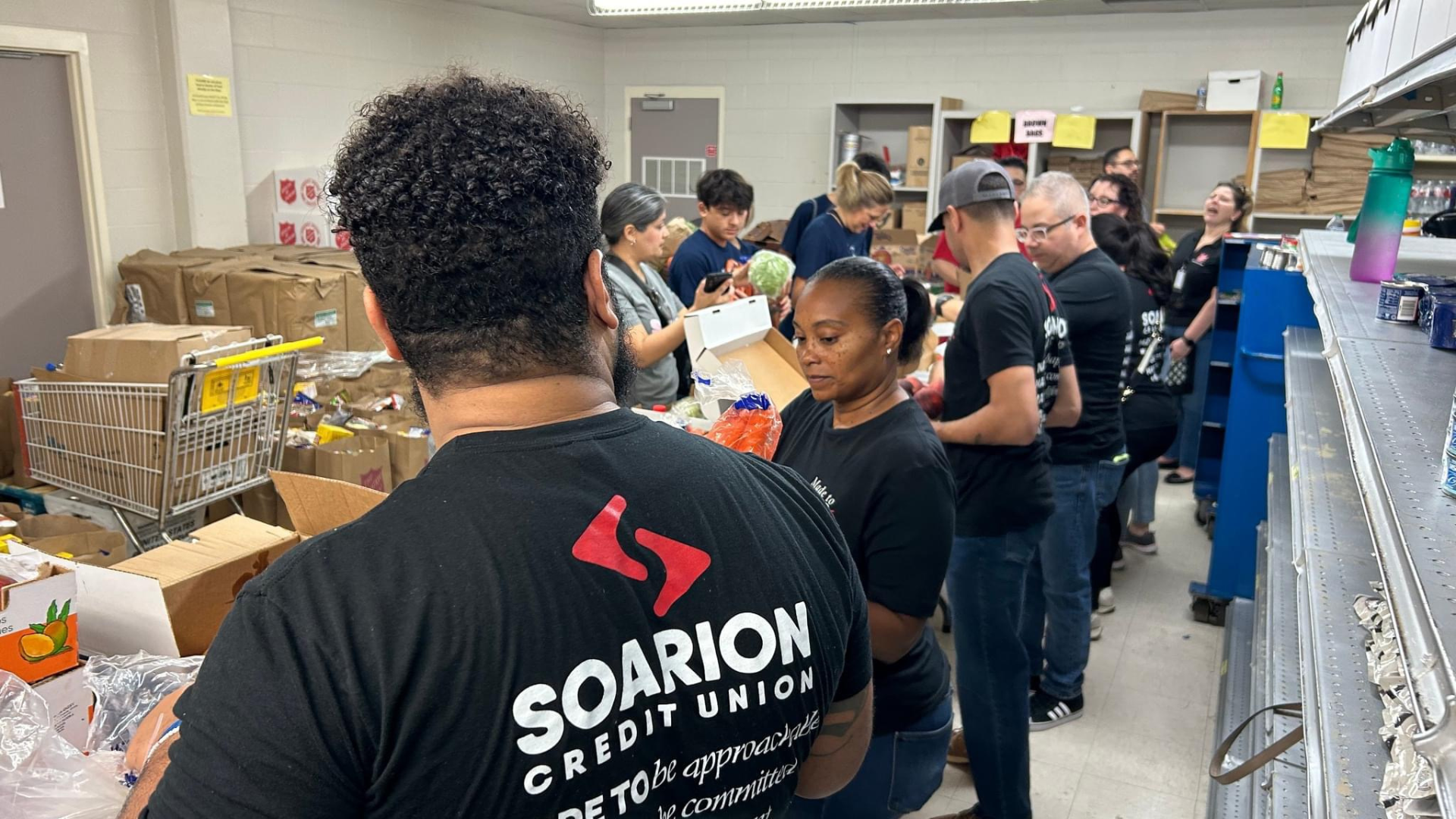Soarion employees volunteering at a food bank pantry Soarion employees volunteering at a food bank pantry