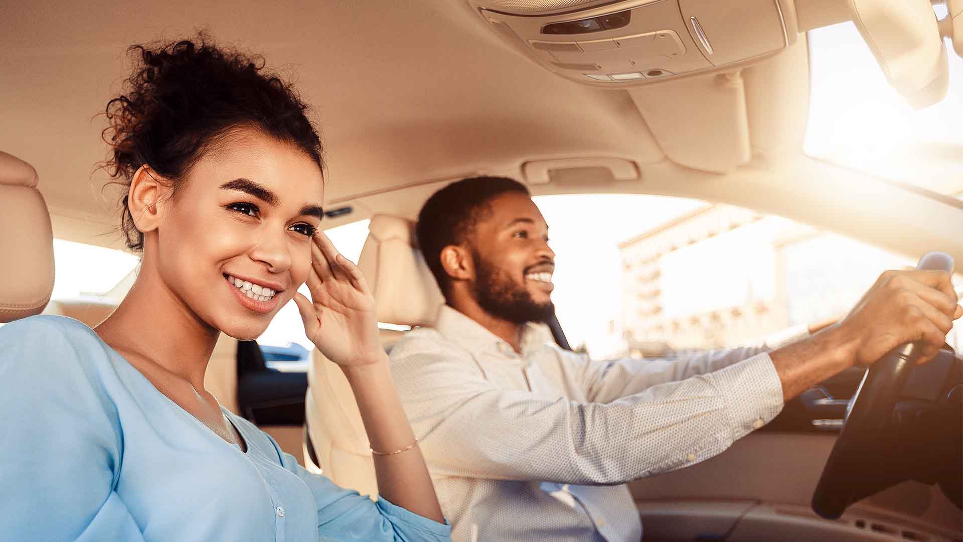 Young couple driving in new car